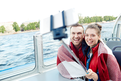 Couple with selfie-stick photographing on cruise tour