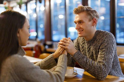 Affectionate couple spending holiday evening in cafe