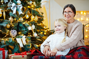 Careful grandmother embracing her granddaughter on Christmas night