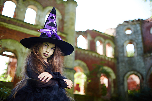 Creepy girl in large witch hat and black attire