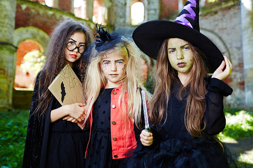 Group of friendly witches in halloween costumes asking you for a treat