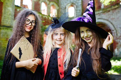 Group of little witches in halloween costumes enjoying outdoor party