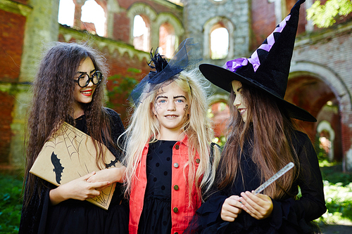 Happy halloween girl  between her friends in witch warlocks