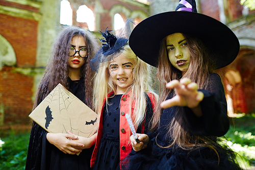 Gloomy little witch and her friends frightening you on halloween day