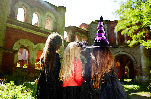 Three girls in witch attire going to play halloween tricks on people