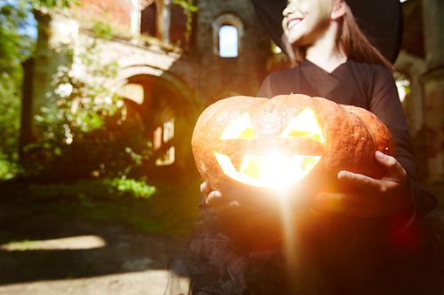 Jack-o-lantern in hands of girl celebrating halloween