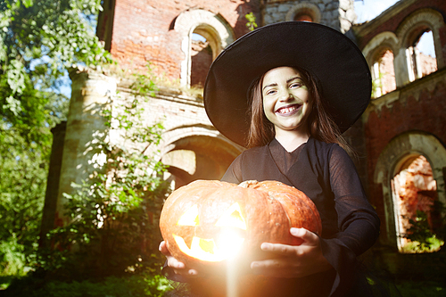 Halloween witch with jack-o-lantern  on sunny day