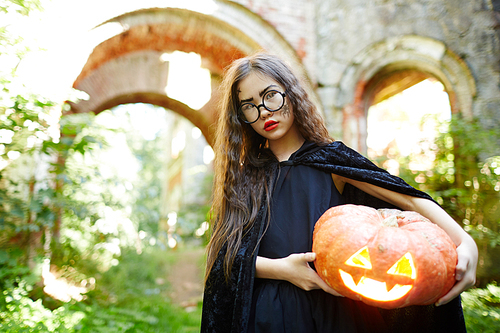 Long-haired girl with carved ripe pumpkin
