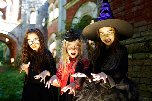 Excited halloween witches with frightening gesture