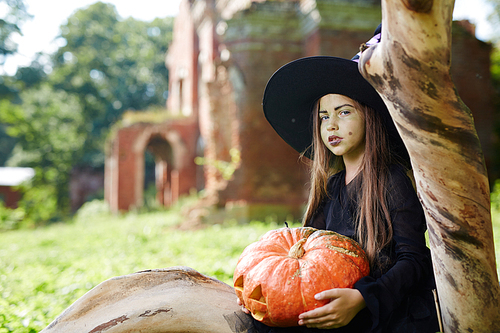 Mysterious witch with pumpkin celebrating halloween