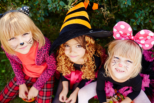 Little girls in costumes of cat, mouse and witch 
