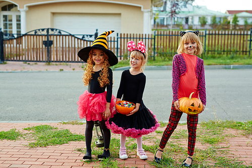 Pretty little girls with halloween treats celebrating traditional holiday