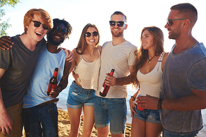 Affectionate buddies with beer enjoying beach party