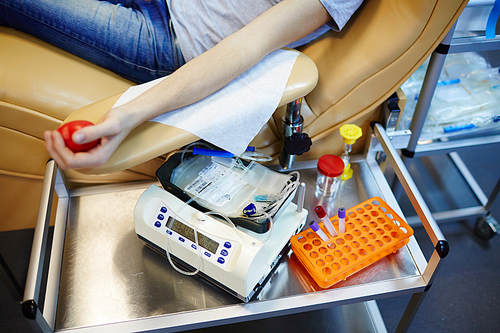 Human arm with flexor and blood-transfusion equipment near by