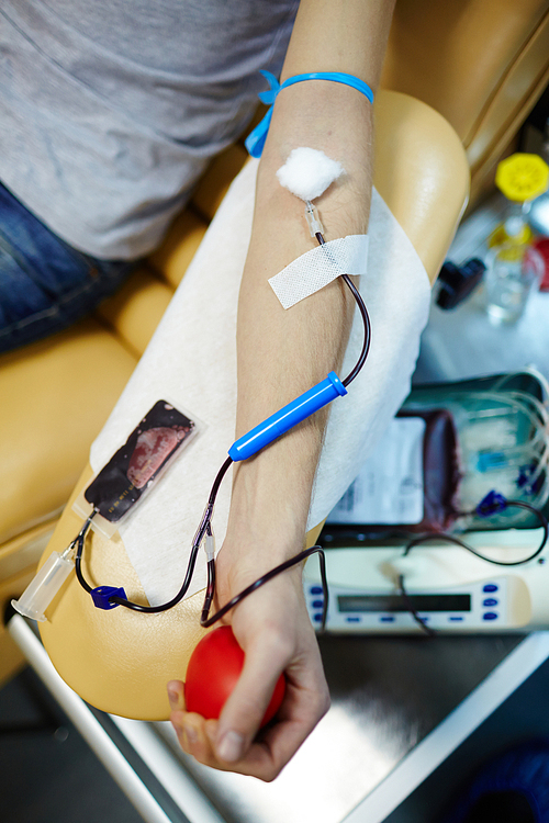 Arm of blood donor with dropper connected to vein