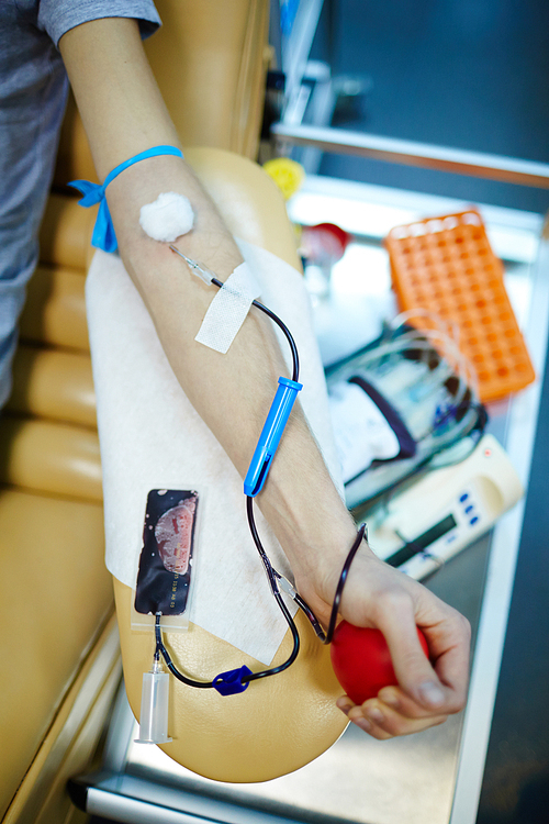 Human hand bound by tourniquet during blood transfusion