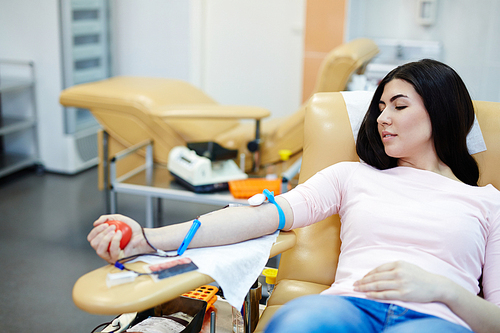 Young woman giving her blood in hemotransfusion center