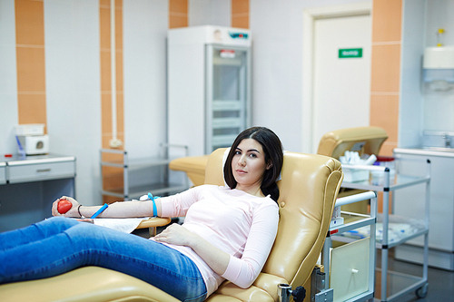 Pretty girl  while sitting in armchair in hospital room