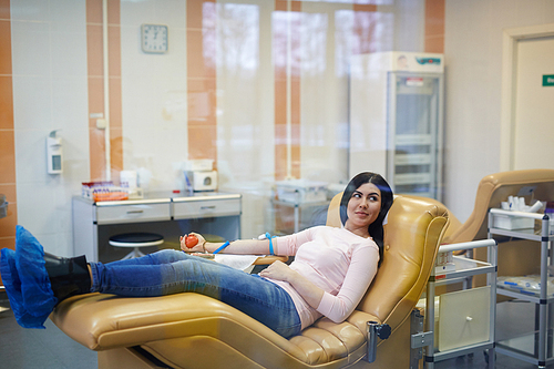 Young female sitting in hemotransfusion center