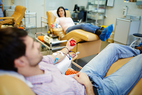 Young man lying in armchair and transfusing blood