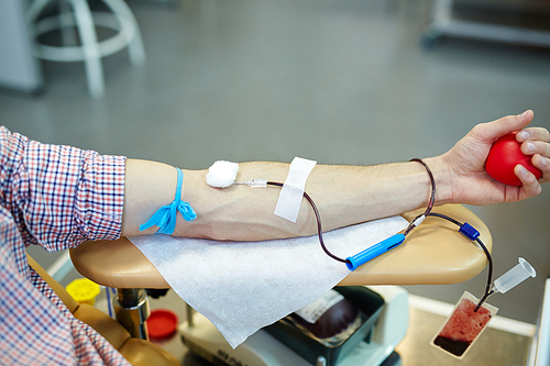 Donor of blood with his arm on armrest