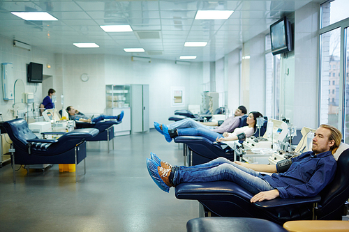 Several donors sitting in blood transfusion center