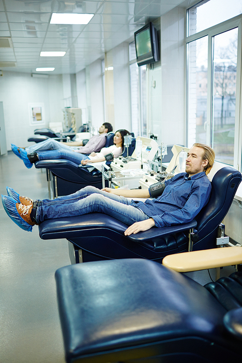 Row of young people donating their blood