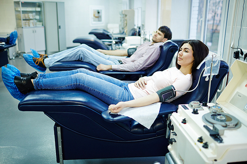 Two young people donating blood in hemotransfusion center