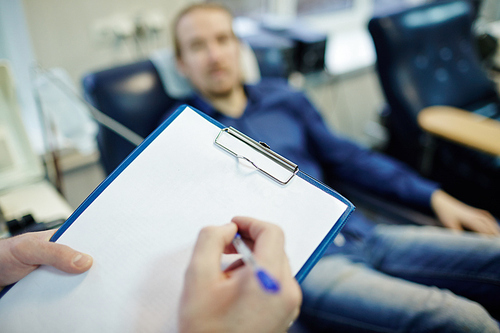 Clinician making notes on blank paper