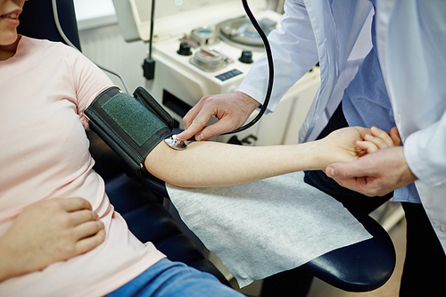 Doctor checking blood pressure of young donor