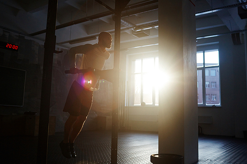 Young man training indoors on sunny day