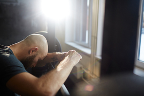 Tired sportsman having rest in gym after training