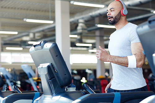 Active young man running on treadmill