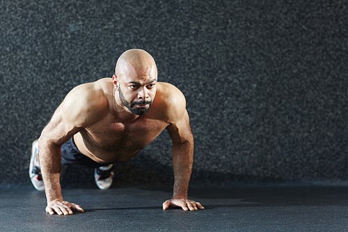 Young muscular man doing push-ups on the floor