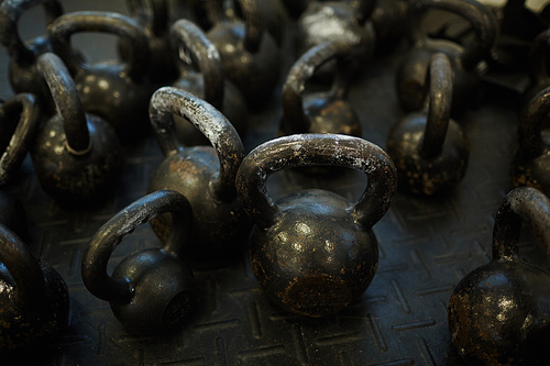 Background image of many tattered kettlebells on floor in gym