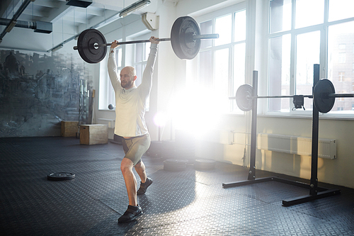 Sportsman keeping balance while lifting weight