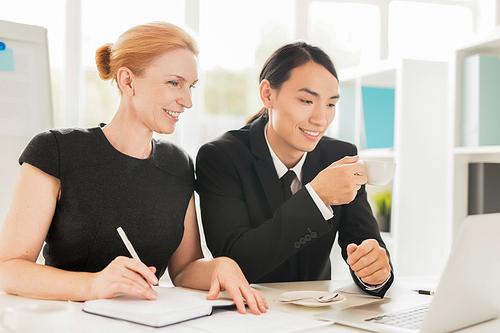 Teamwork of analysts looking through online statistics in office