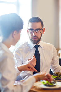 Confident expert consulting colleague or explainign his view point by lunch in cafe