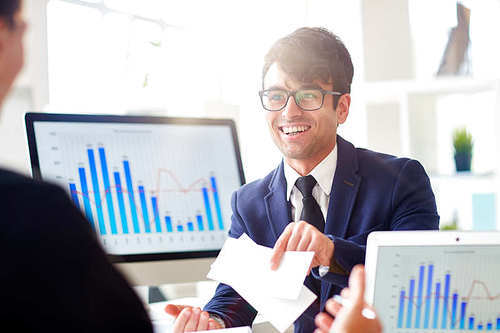 Successful man in suit showing two tickets on entertaining event to colleague