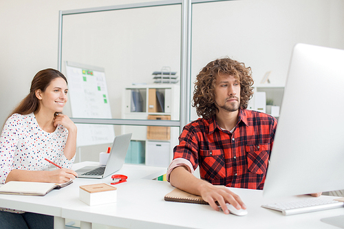 Two young designers studying online course for beginners in office