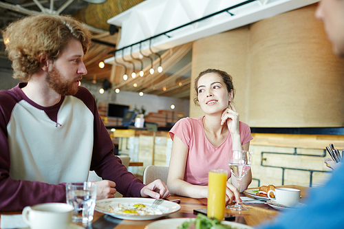 College friends discussing homework while having lunch in cafe