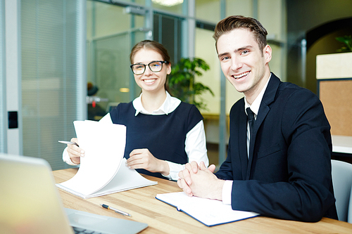 Young bankers working with papers and reading contracts in office