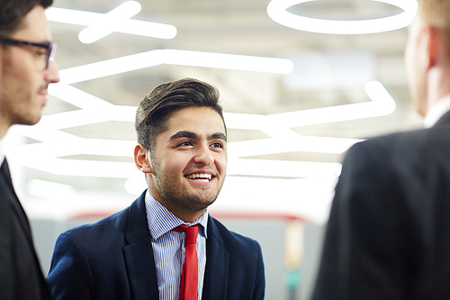 Happy young manager communicating to colleagues at start-up meeting