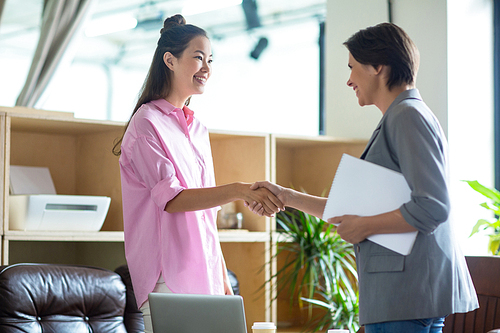 Two successful businesswomen handshaking after negotiation