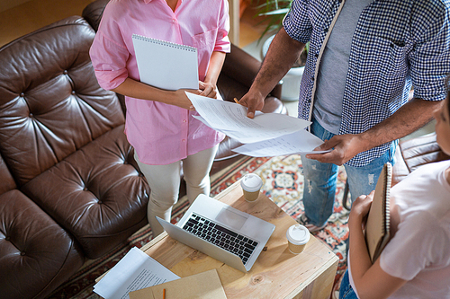 Contemporary economists discussing financial papers over workplace