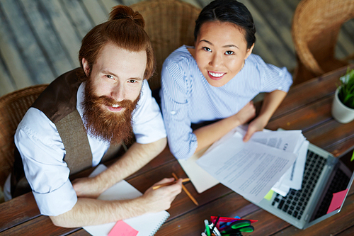 High angle portrait of modern creative business team looking up at camera and smiling while working in meeting