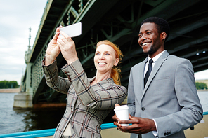 Cheerful business people making their selfie on smartphone during travel