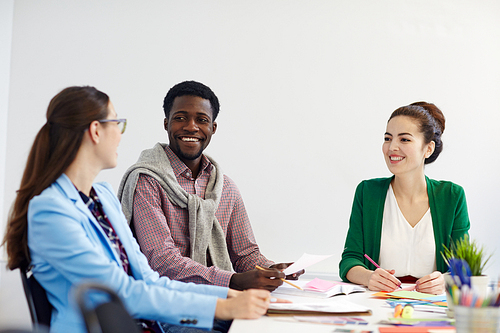 Happy business team having discussion of new project or working ideas