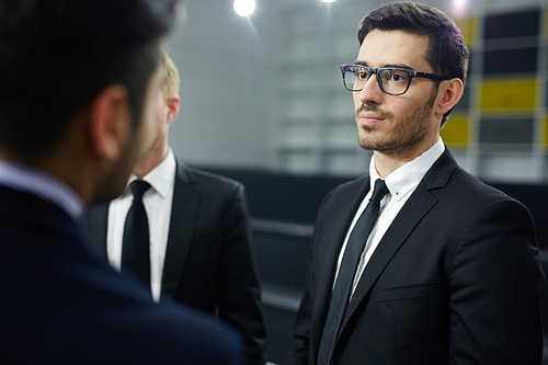 Serious delegates in elegant suits and ties discussing or solving political problems at meeting