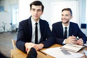 Happy leader handshaking with new partner or employee